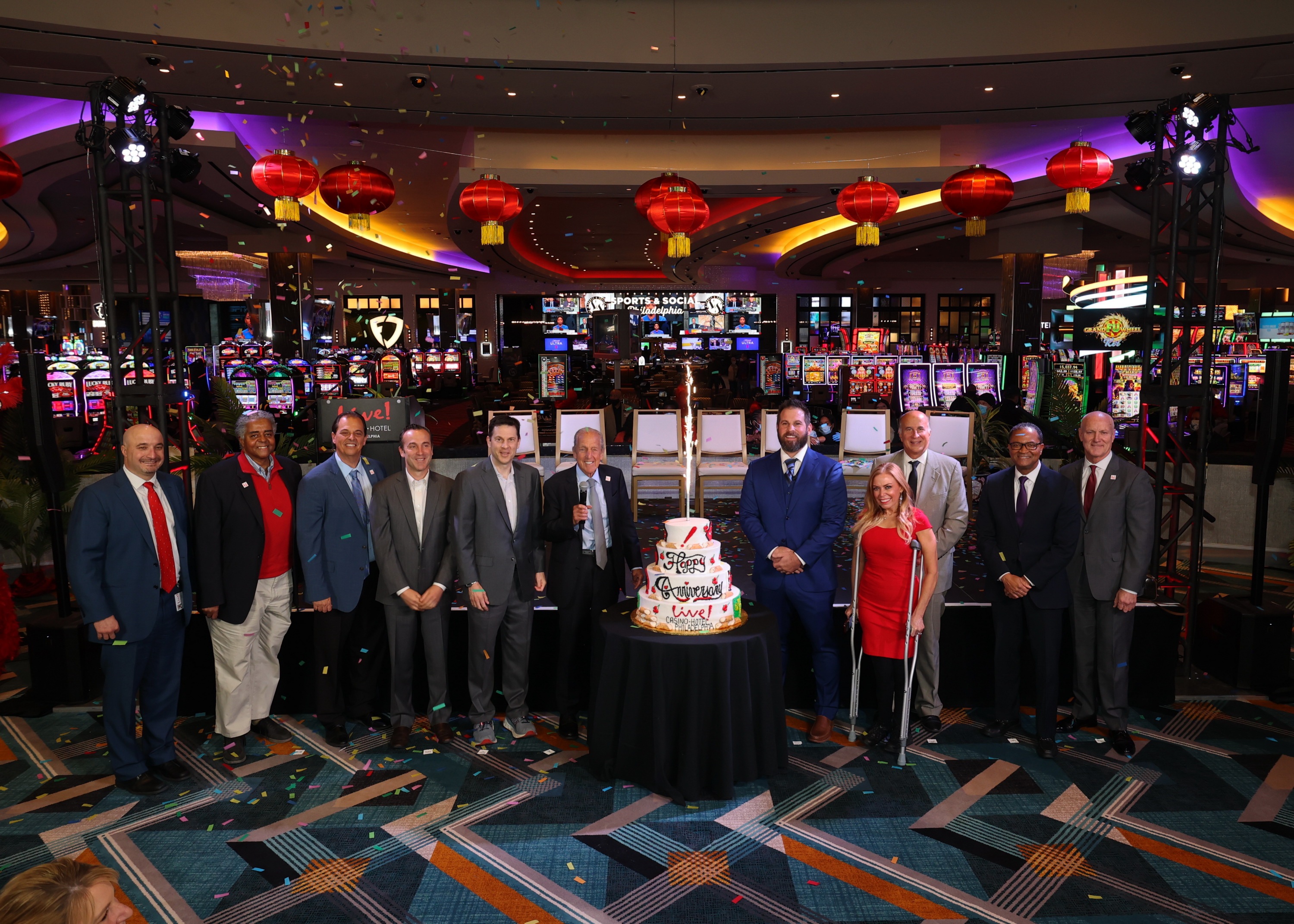 Photo of executives of the Cordish Group stand with a cake inside of Live! Casino & Hotel Philadelphia at the land-based casino's one-year anniversary celebration. The casino opened mid-pandemic and has has great success against the odds.